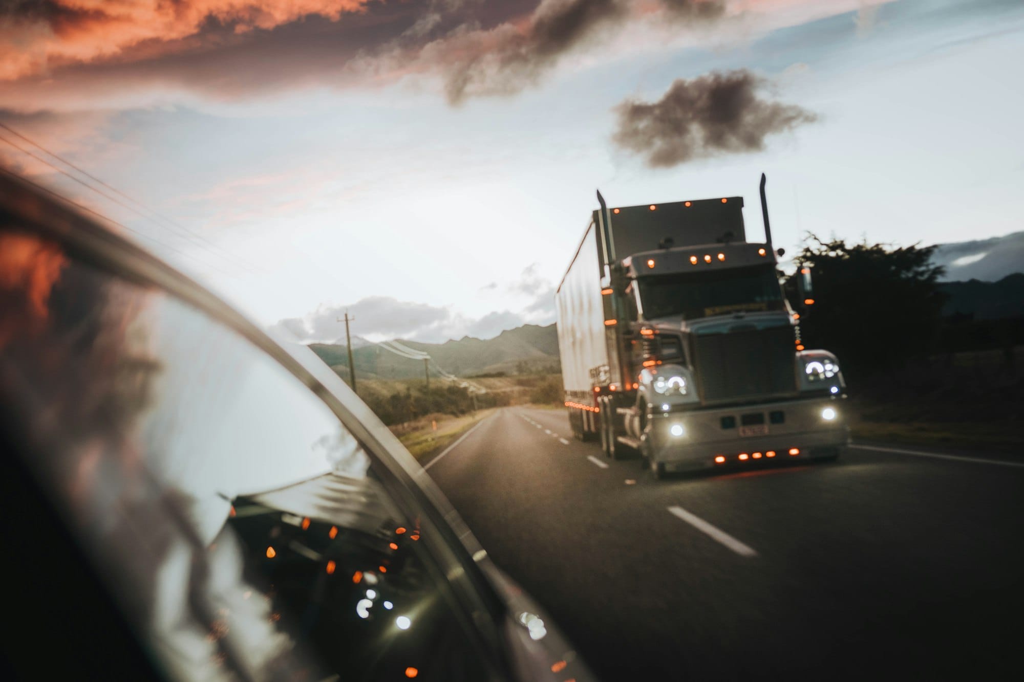Camion semi-remorque sur l'autoroute au coucher du soleil