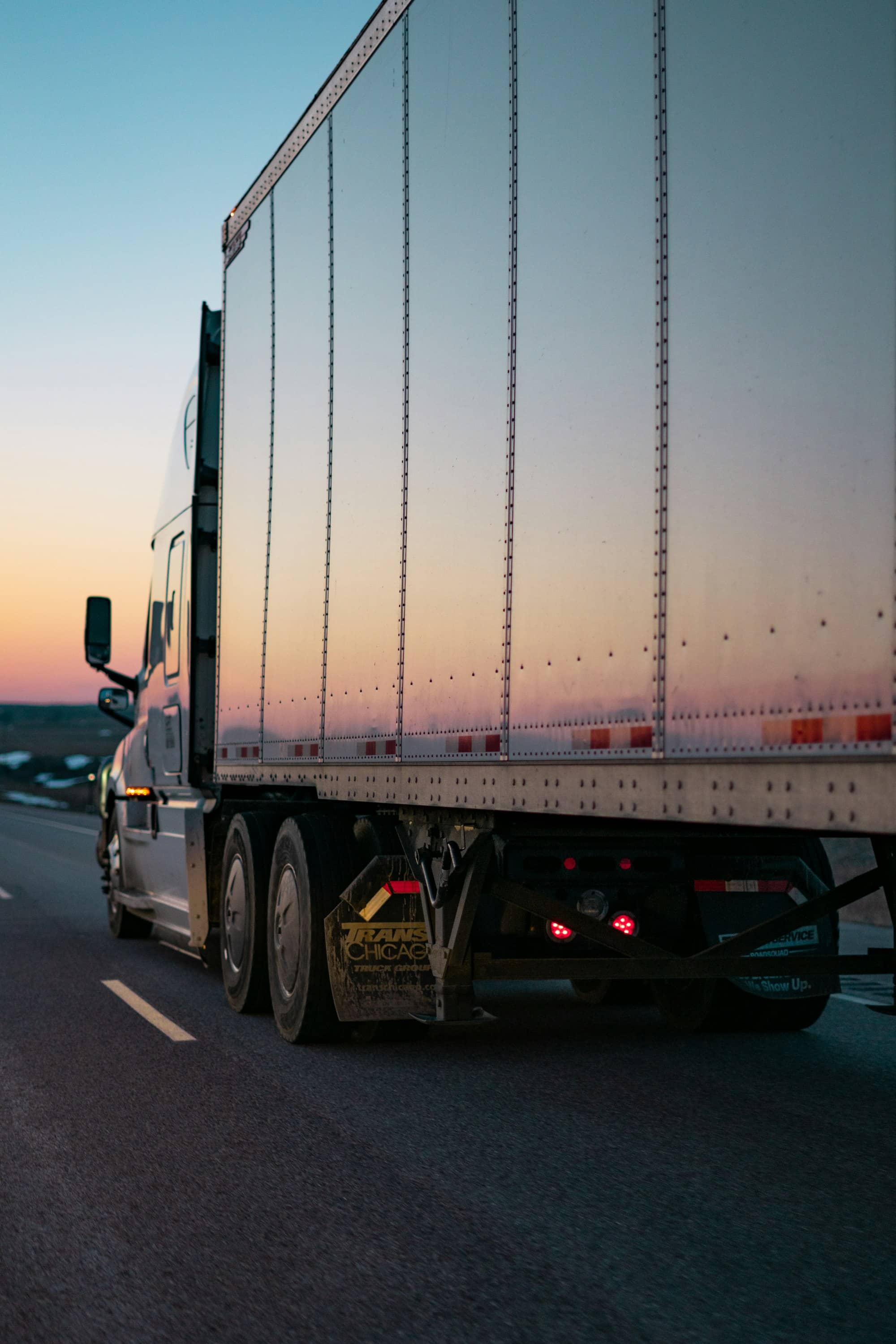 Semi-remorque réfrigérée sur la route au coucher du soleil